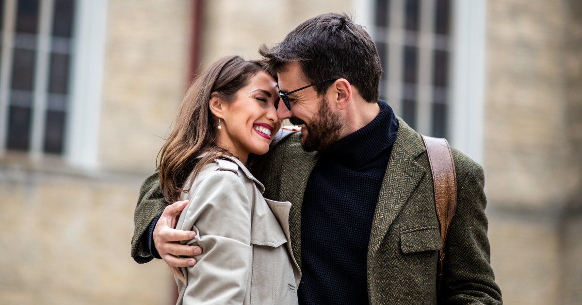 Šťastný pár sa usmieva a pôsobí uvoľnene - symbol pomalého, prirodzeného a zdravého budovania vzťahu.